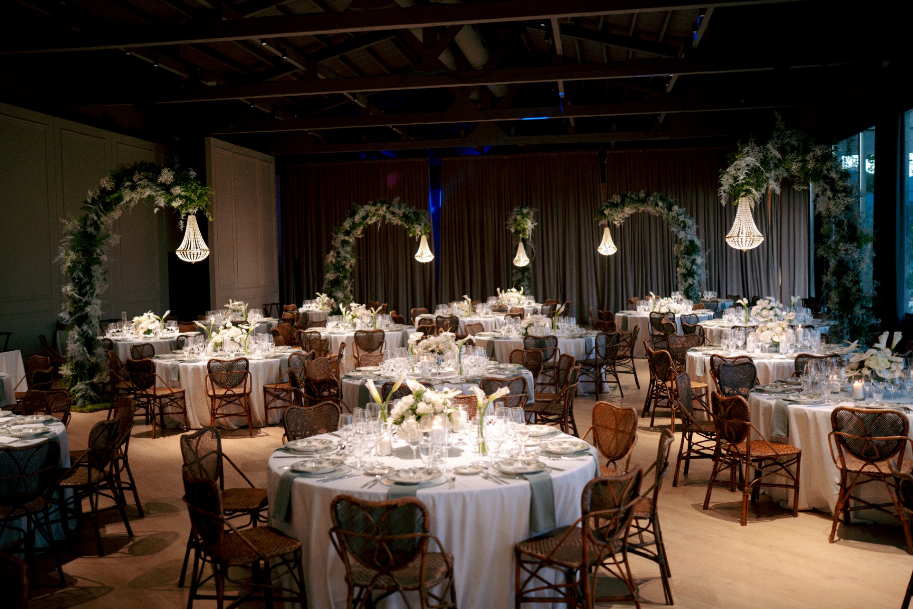 Banquete elegante con arcos florales y lámparas de araña